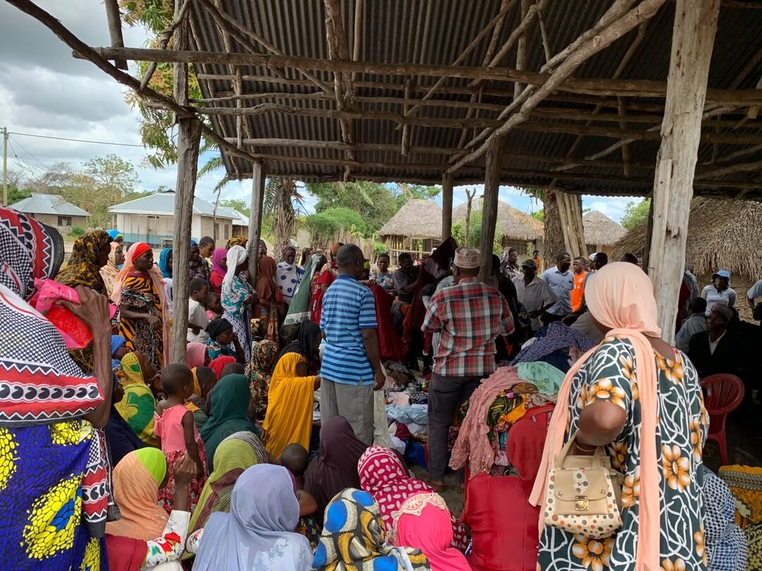 Community gathered under a shelter for outreach