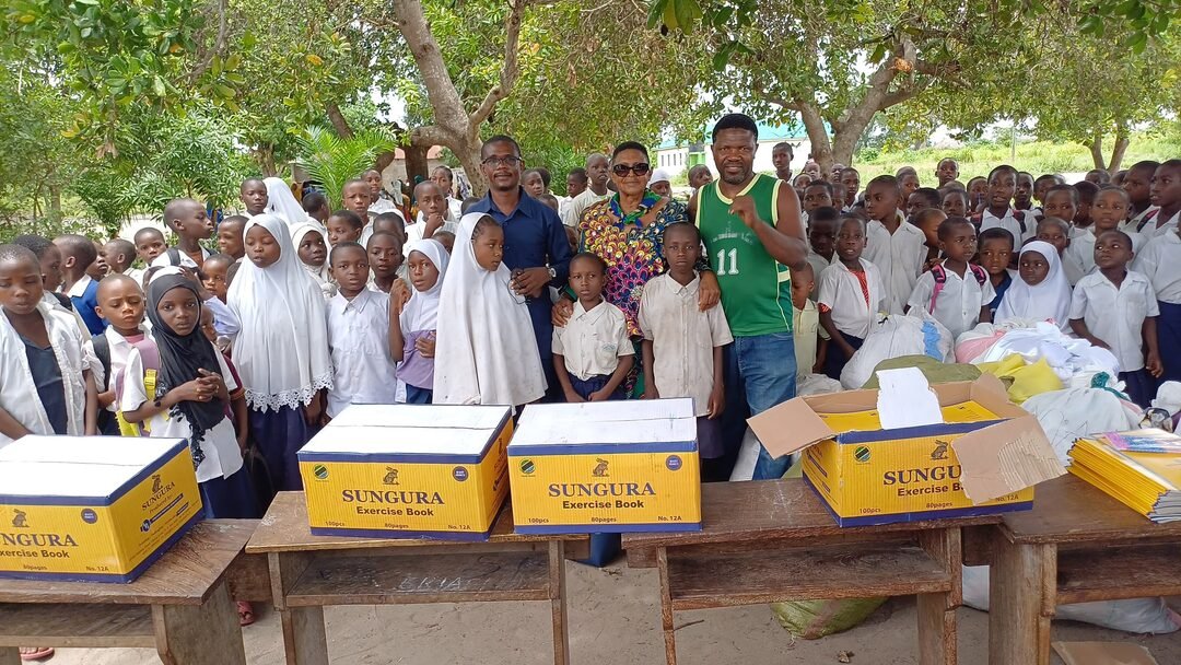 Schoolchildren gathered around donated exercise books